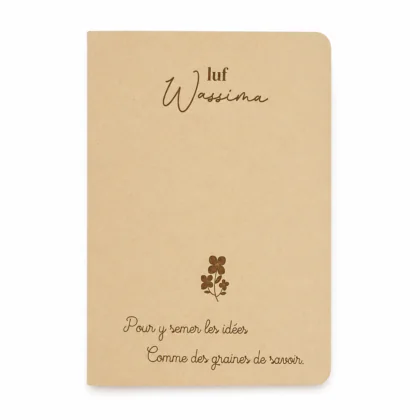 Carnet à couverture souple en papier kraft naturel, personnalisé avec le prénom "Wassima" en haut, un motif floral au centre, et la phrase inscrite en bas : "Pour y semer les idées, comme des graines de savoir".