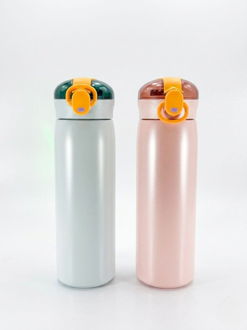 Paire de bouteilles isothermes pour enfant, l'une de couleur gris clair avec un bouchon vert foncé et l'autre de couleur rose avec un bouchon marron, toutes deux équipées d'un mécanisme de verrouillage jaune.