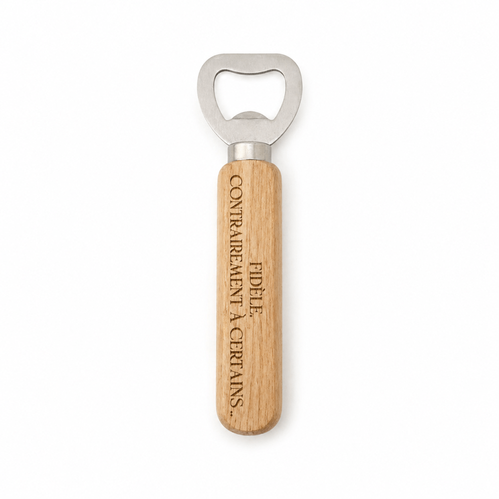 Décapsuleur manuel composé d'une tête en acier inoxydable et d'un manche cylindrique en bois clair gravé verticalement de la phrase humoristique "FIDÈLE. CONTRAIREMENT À CERTAINS...".